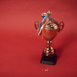A Trophy with Tied Ribbons on Red Background