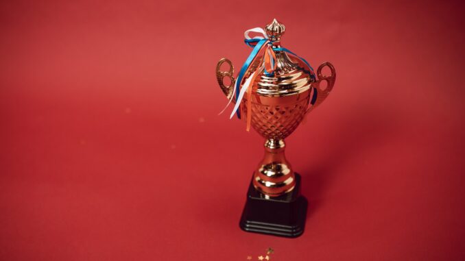 A Trophy with Tied Ribbons on Red Background