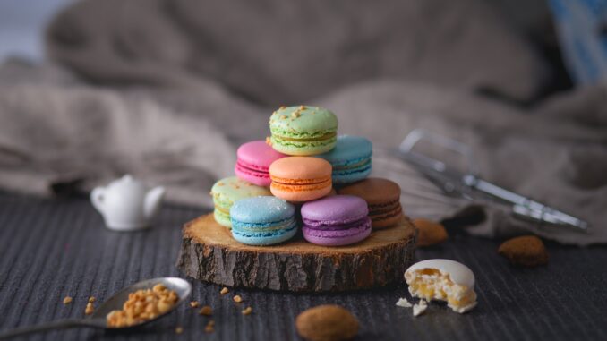 assorted-color macaroons on wood slab