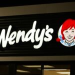 A wendy's sign is lit up at night