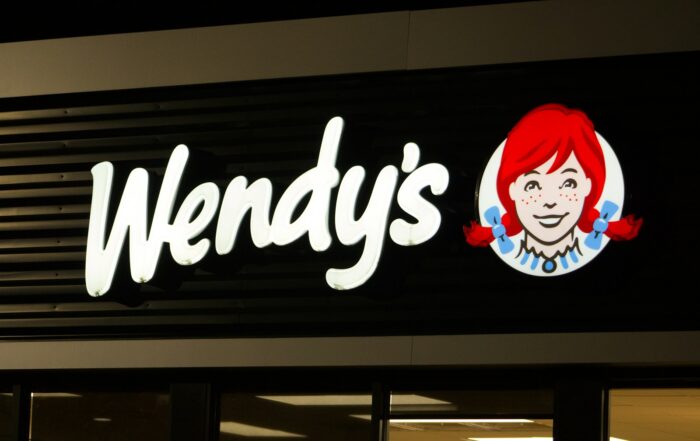 A wendy's sign is lit up at night
