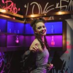 smiling woman in grey and black checked tube dress in bar