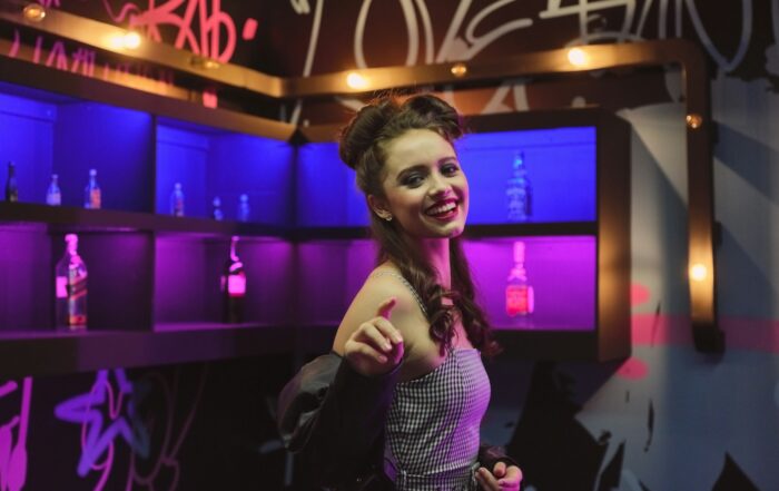 smiling woman in grey and black checked tube dress in bar