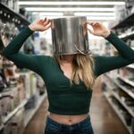 woman in blue long sleeve shirt holding stainless steel mug